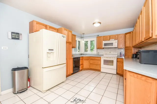 a kitchen with stainless steel appliances a refrigerator sink and microwave