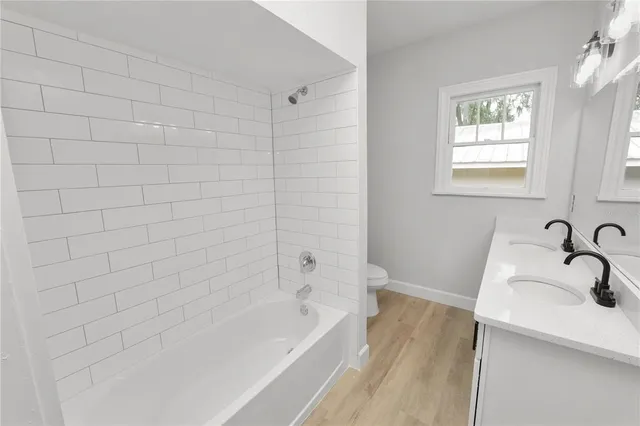 a bathroom with a tub a sink and a window