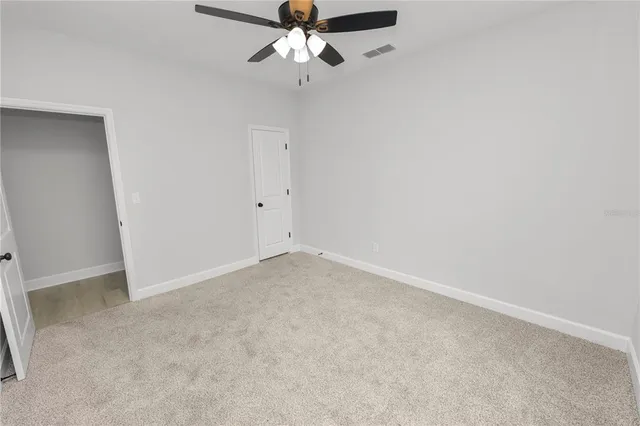 an empty room with a chandelier fan