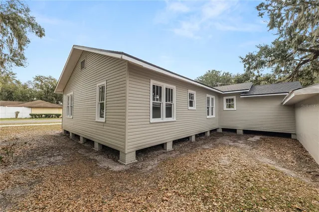 a view of a house with a yard and wooden fence