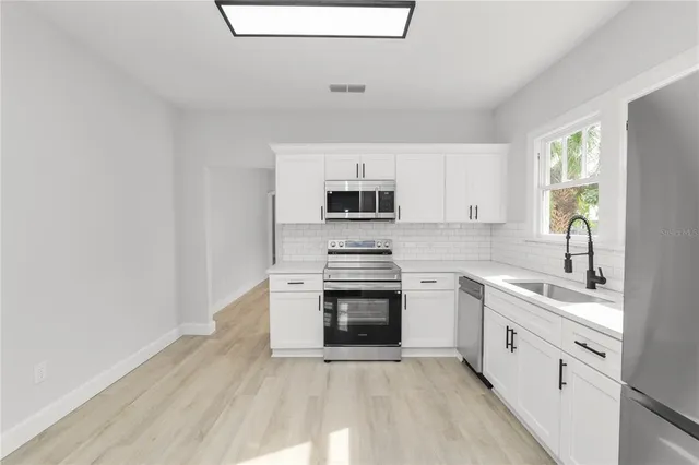 a kitchen with a sink stove and microwave
