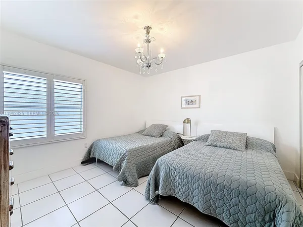 a bedroom with two beds and a chandelier