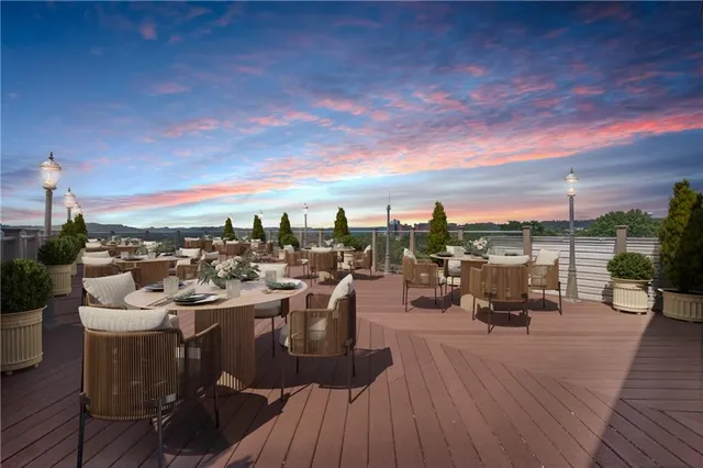 a living room with couches and kitchen view with wooden floor