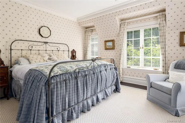 a bedroom with a bed and large windows