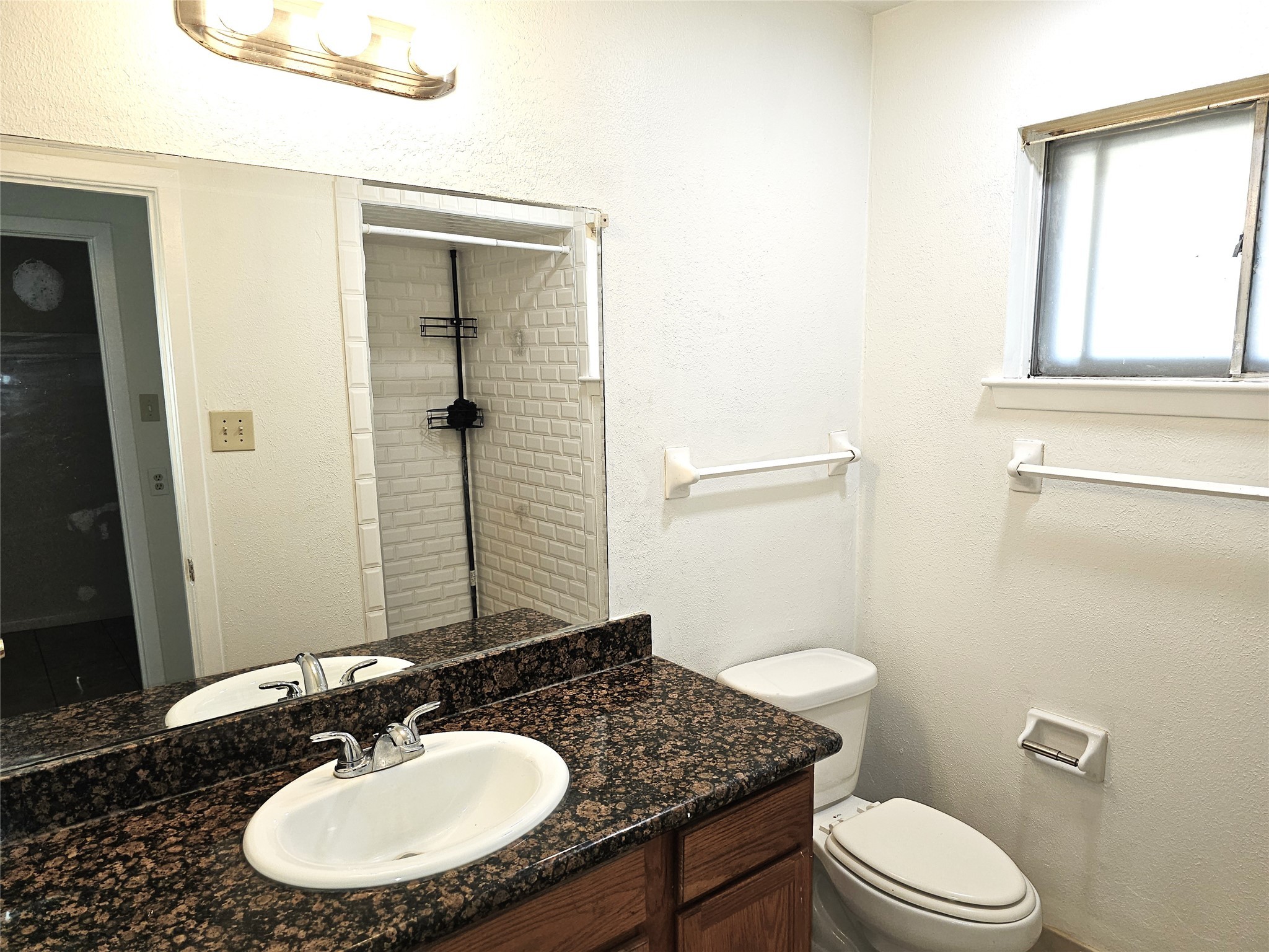 11427 Kirkmeadow Drive Houston, TX 77089 - Photo 17 of 24 a bathroom with a granite countertop sink toilet a mirror and a window