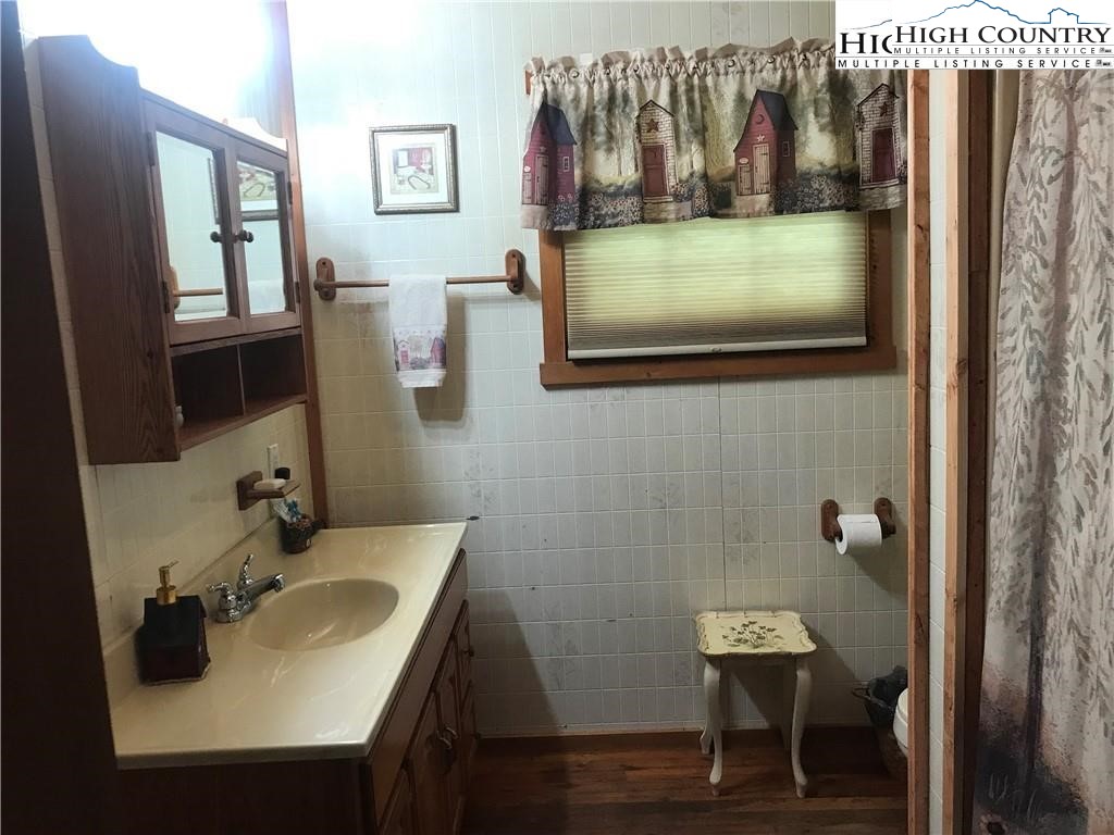 2232 Greer Town Road Lansing, NC 28643 - Photo 14 of 28 a bathroom with a sink a mirror and a toilet