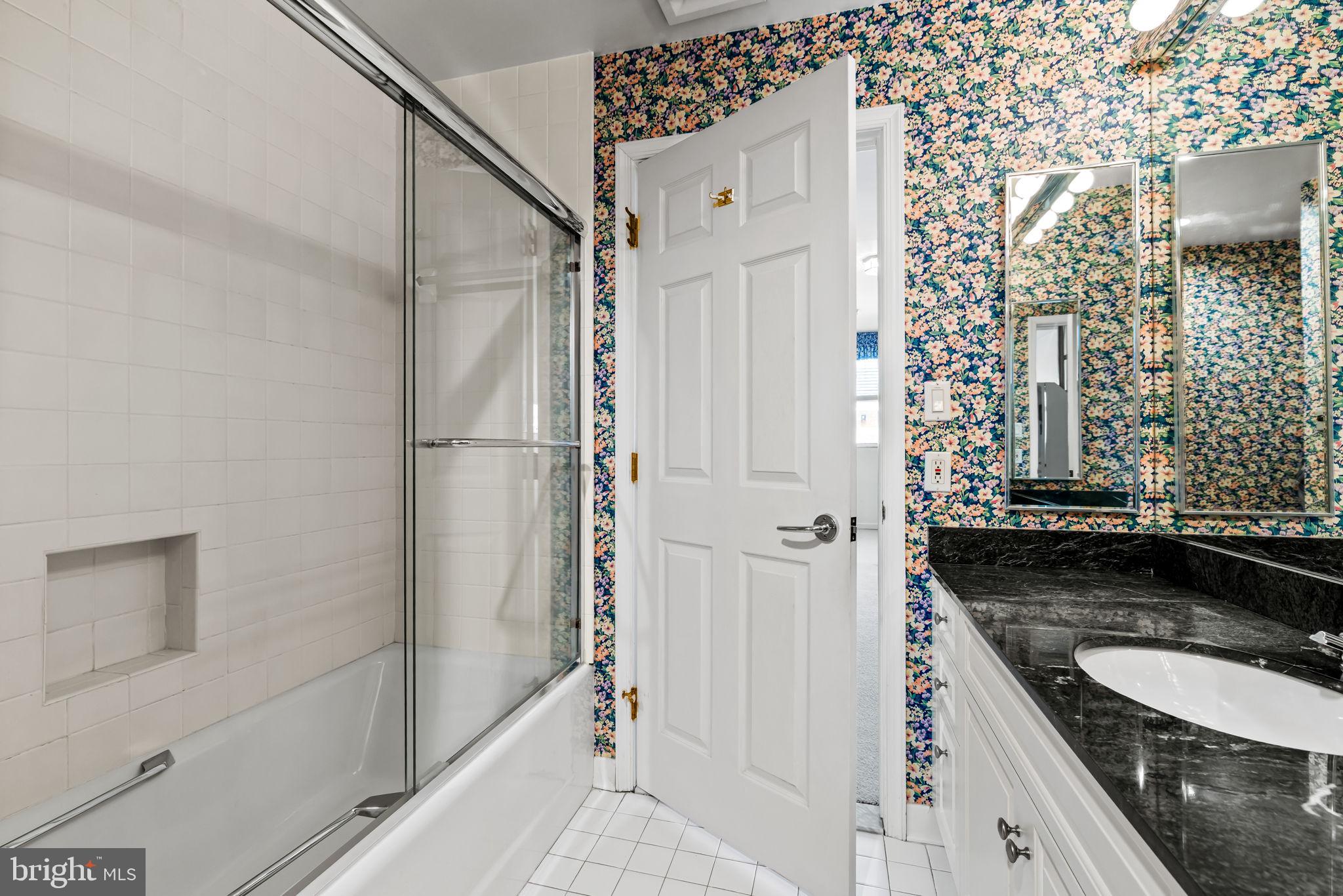 3801 Canterbury Road, Unit 1104 Baltimore, MD 21218 - Photo 54 of 74 a bathroom with a granite countertop shower a mirror and a sink