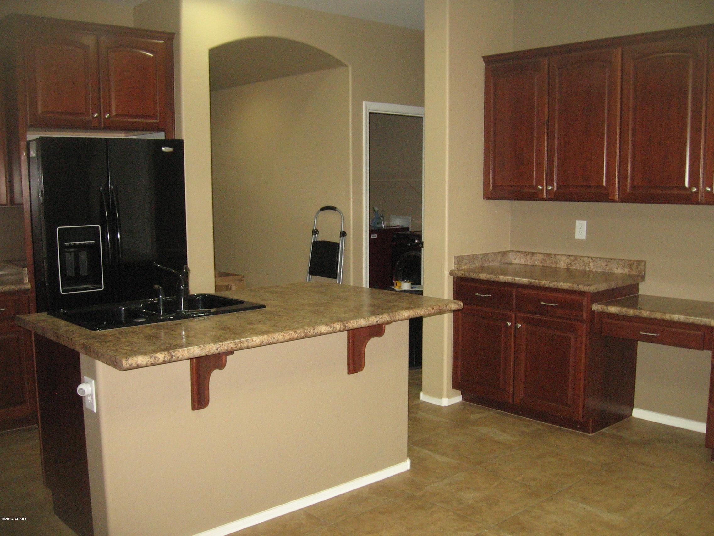 18022 West Hatcher Road Waddell, AZ 85355 - Photo 4 of 38 a kitchen with stainless steel appliances granite countertop a stove a refrigerator and a oven