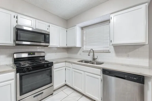 a kitchen with a sink stove and microwave