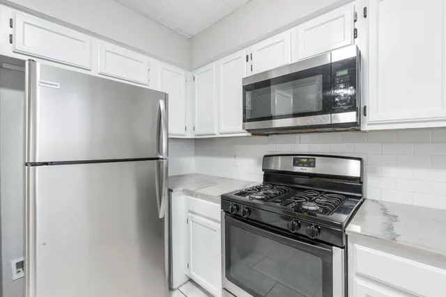 a kitchen with a refrigerator stove and microwave