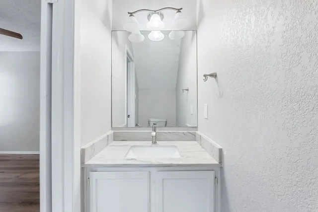 a bathroom with a granite countertop sink and a mirror