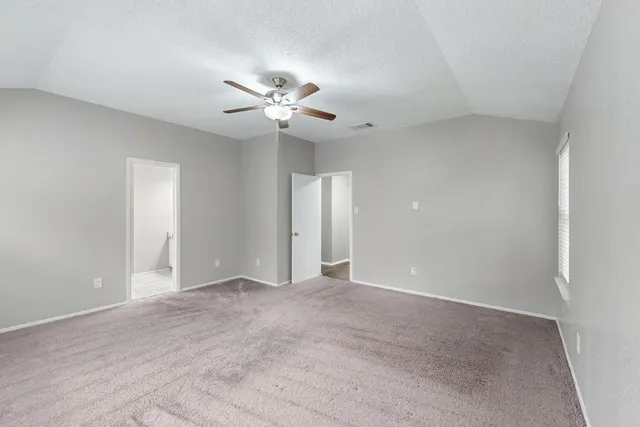 a view of an empty room with a ceiling fan