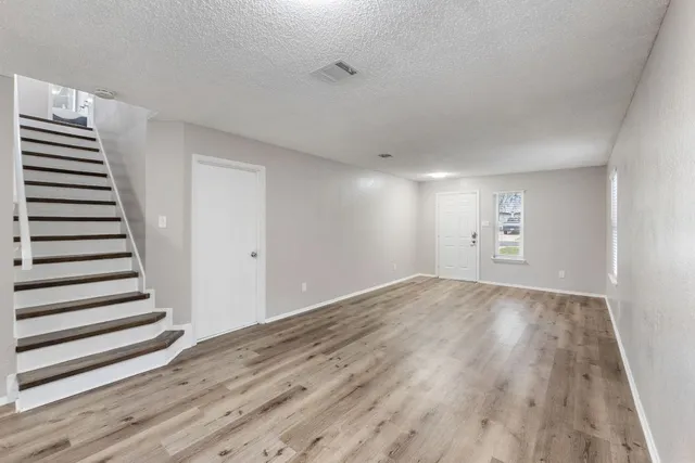 a view of a room with wooden floor and white walls