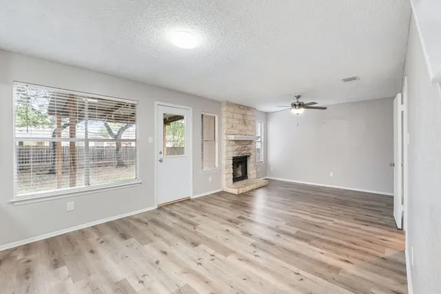 a view of empty room with wooden floor and fireplace