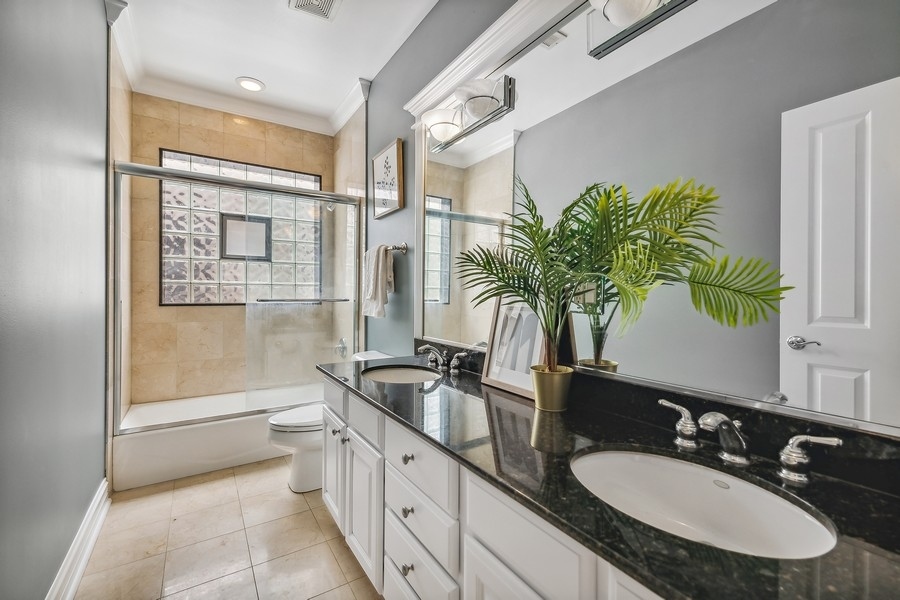 1359 North Mohawk Street, Unit 2 Chicago, IL 60610 - Photo 18 of 23 a bathroom with a granite countertop sink a mirror and a shower