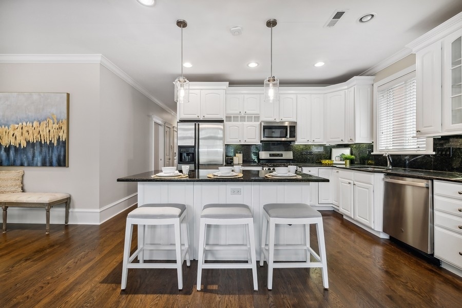 1359 North Mohawk Street, Unit 2 Chicago, IL 60610 - Photo 9 of 23 a kitchen with stainless steel appliances granite countertop a white cabinets and wooden floor