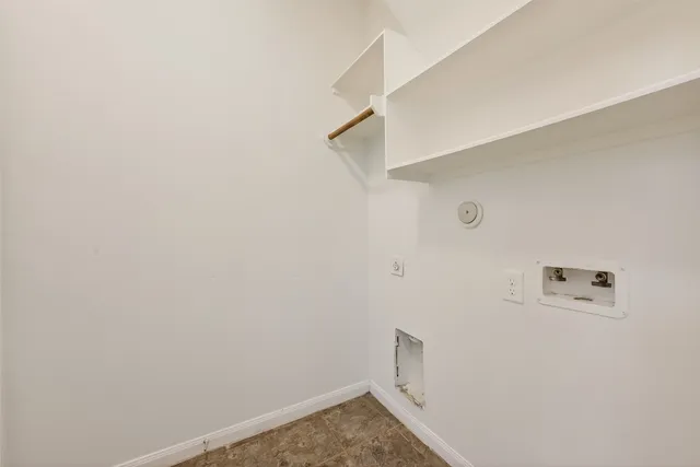 a view of an empty room with wooden floor and a ceiling fan