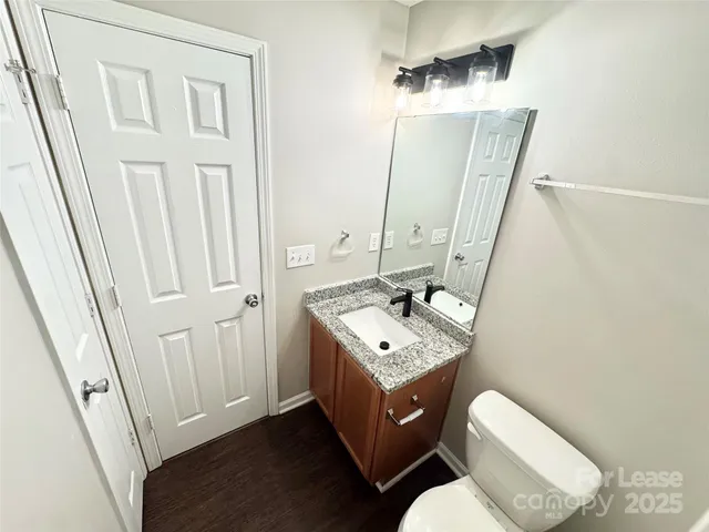 a bathroom with a sink a toilet a mirror and vanity