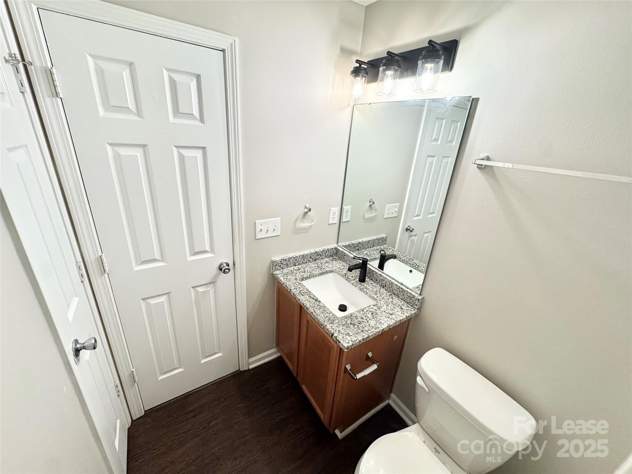 327 Flint Hill Road, Unit 203 Fort Mill, SC 29715 - Photo 14 of 18 a bathroom with a sink a toilet a mirror and vanity
