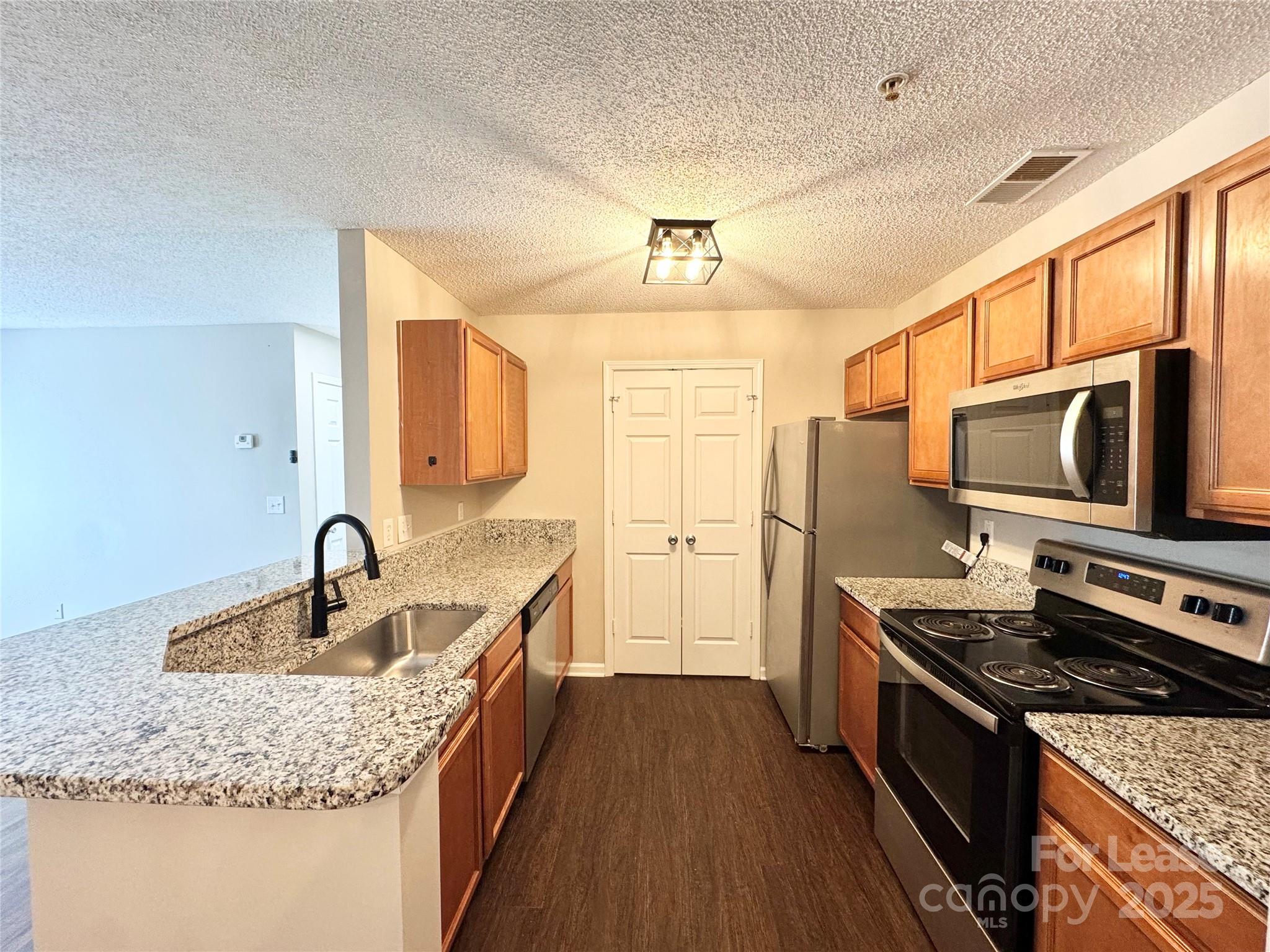 327 Flint Hill Road, Unit 203 Fort Mill, SC 29715 - Photo 2 of 18 a kitchen with stainless steel appliances granite countertop a sink stove and refrigerator