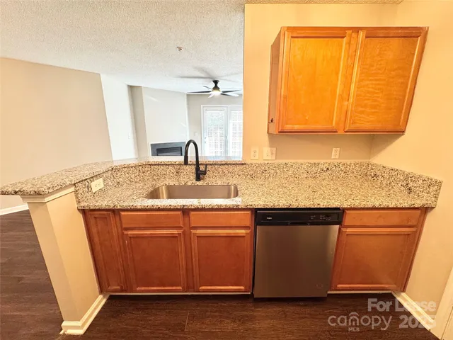 a kitchen with stainless steel appliances granite countertop a sink and a refrigerator