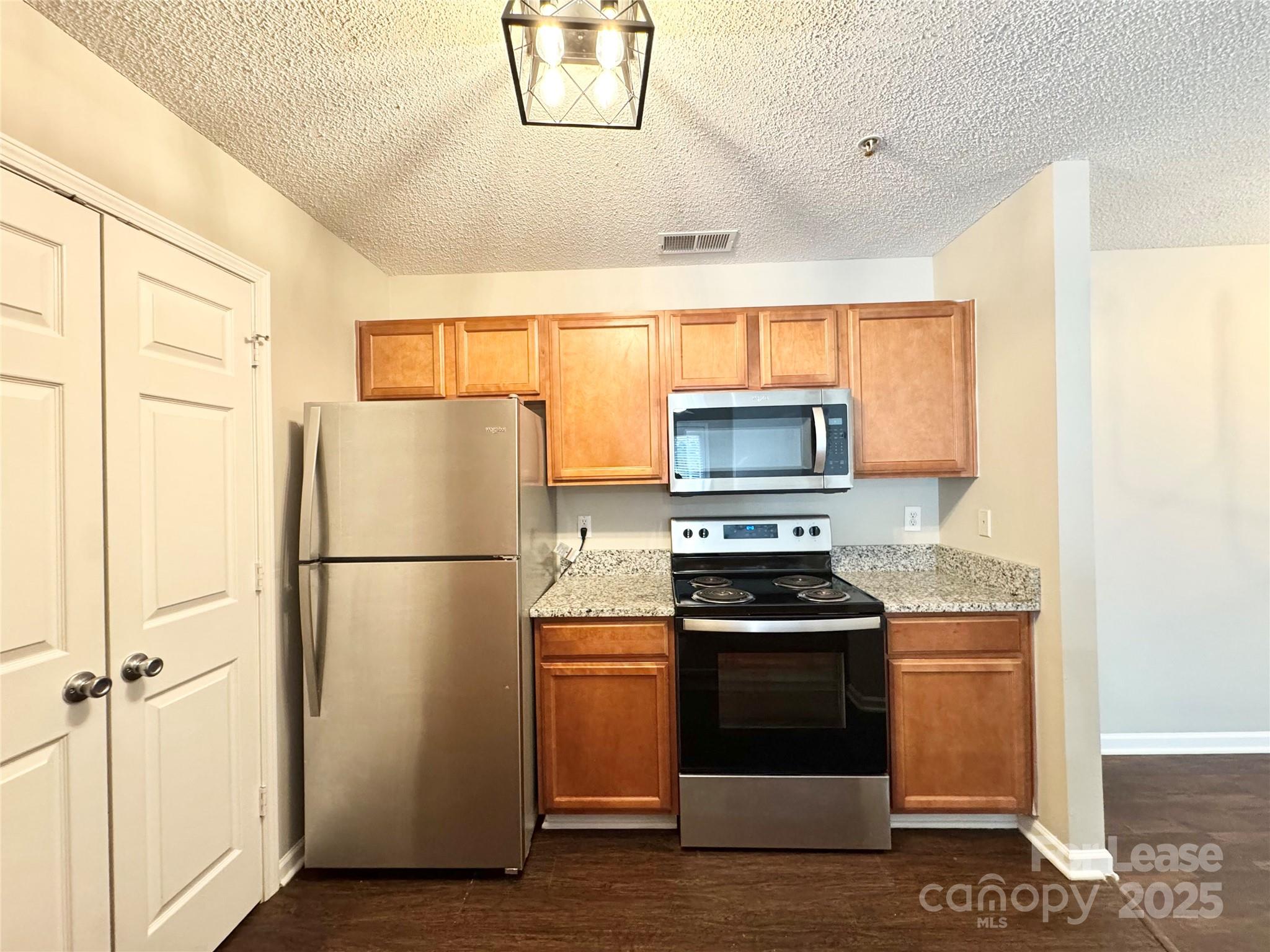 327 Flint Hill Road, Unit 203 Fort Mill, SC 29715 - Photo 4 of 18 a kitchen with a refrigerator stove and microwave