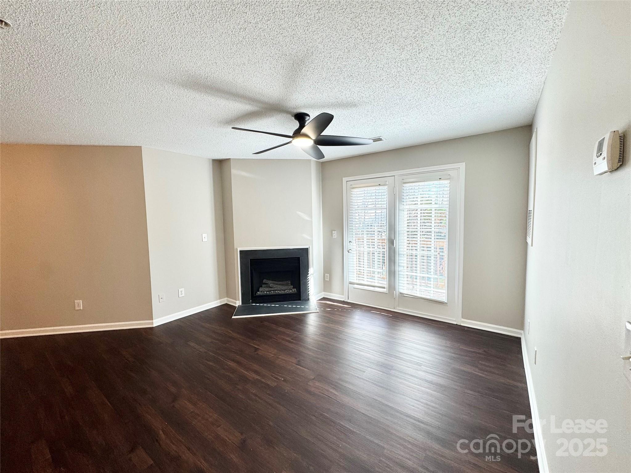 327 Flint Hill Road, Unit 203 Fort Mill, SC 29715 - Photo 6 of 18 a view of an empty room with wooden floor and a window