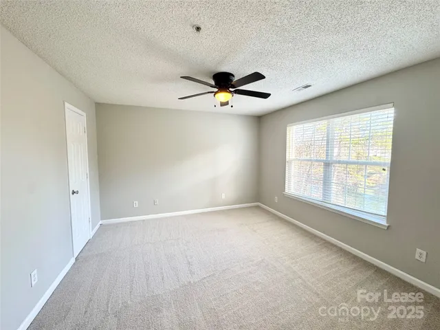 an empty room with fan and windows
