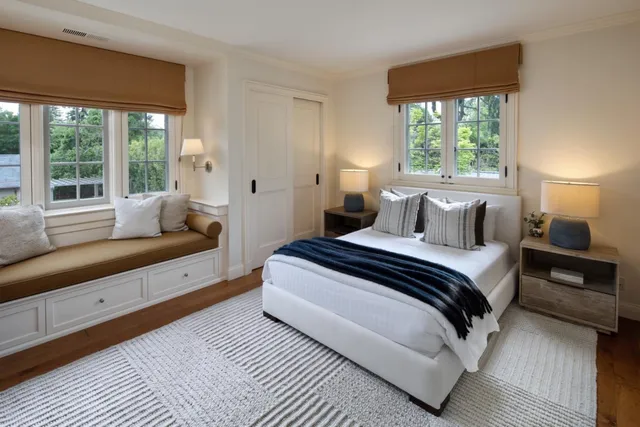 a bedroom with a bed and large window