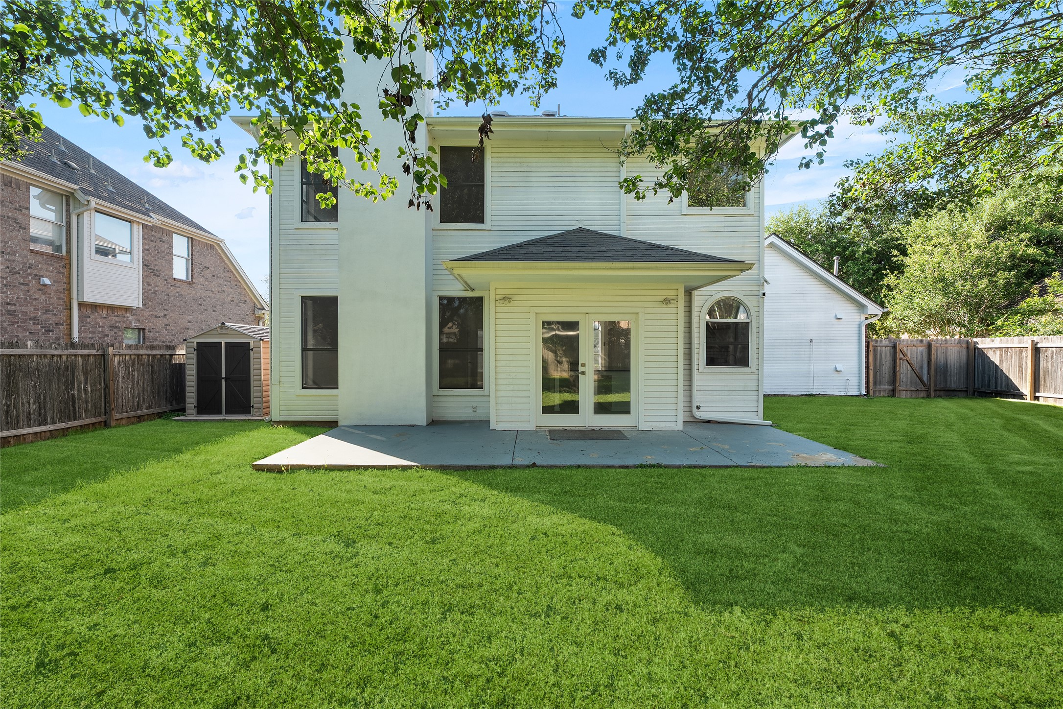 206 River Down Road Georgetown, TX 78628 - Photo 34 of 39 Expansive backyard featuring a manicured lawn, a concrete patio, and a storage shed