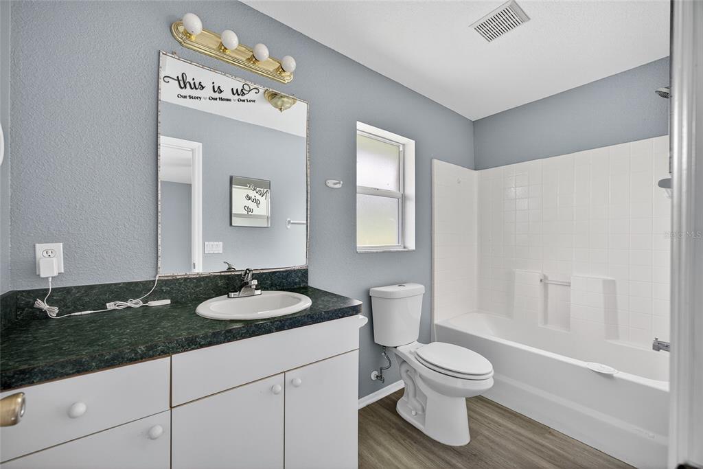 1071 Nomad Road Punta Gorda, FL 33983 - Photo 12 of 22 a bathroom with a granite countertop sink toilet a mirror and bathtub