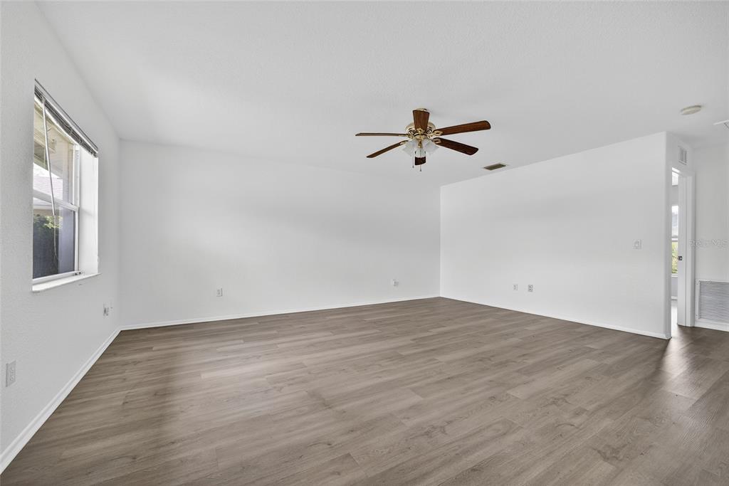 1071 Nomad Road Punta Gorda, FL 33983 - Photo 4 of 22 an empty room with wooden floor and windows