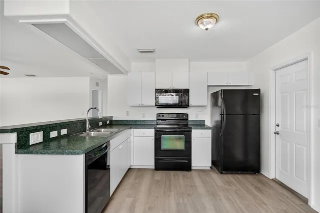 a kitchen with a refrigerator and a stove top oven