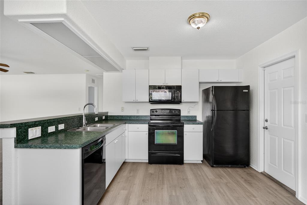 1071 Nomad Road Punta Gorda, FL 33983 - Photo 7 of 22 a kitchen with a refrigerator and a stove top oven