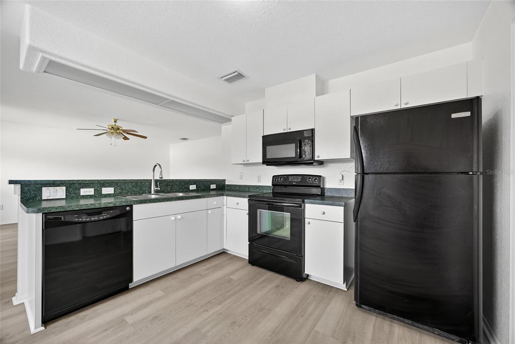1071 Nomad Road Punta Gorda, FL 33983 - Photo 9 of 22 a kitchen with a refrigerator and a stove top oven