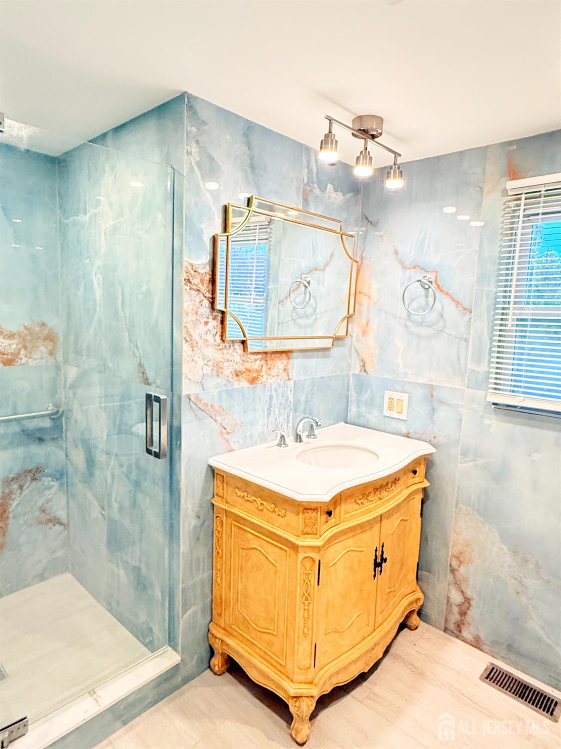 385 Pierson Avenue, Unit 1 Edison, NJ 08837 - Photo 13 of 17 a bathroom with a sink a mirror and a shower