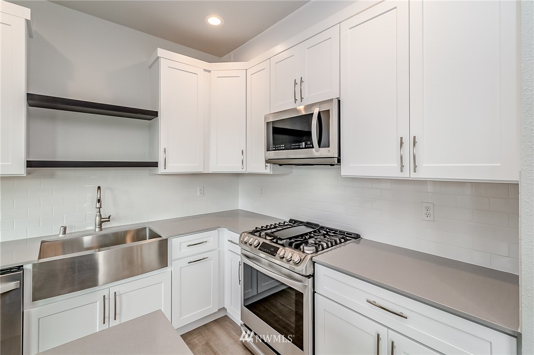 2720 Callow Road, Unit A Lake Stevens, WA 98258 - Photo 12 of 32 a kitchen with stainless steel appliances granite countertop white cabinets sink and stove