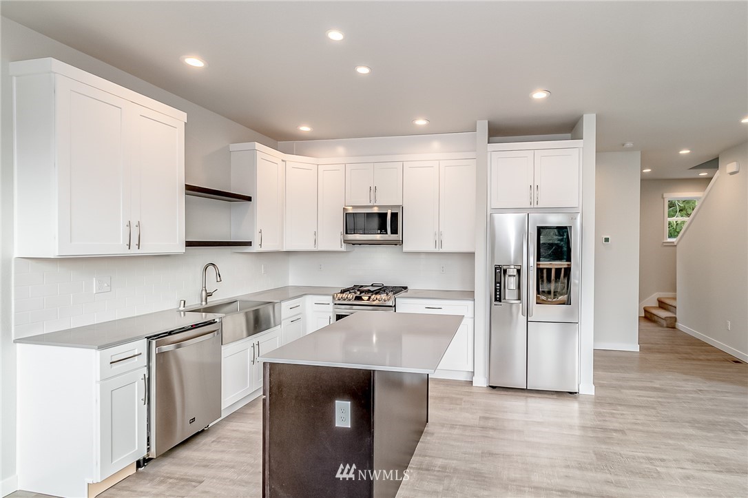 2720 Callow Road, Unit A Lake Stevens, WA 98258 - Photo 9 of 32 a kitchen with stainless steel appliances granite countertop a refrigerator oven a sink dishwasher and white cabinets with wooden floor