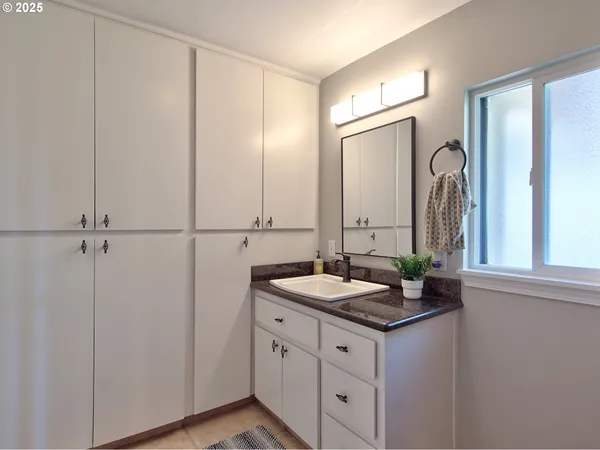 a bathroom with a granite countertop sink and a mirror