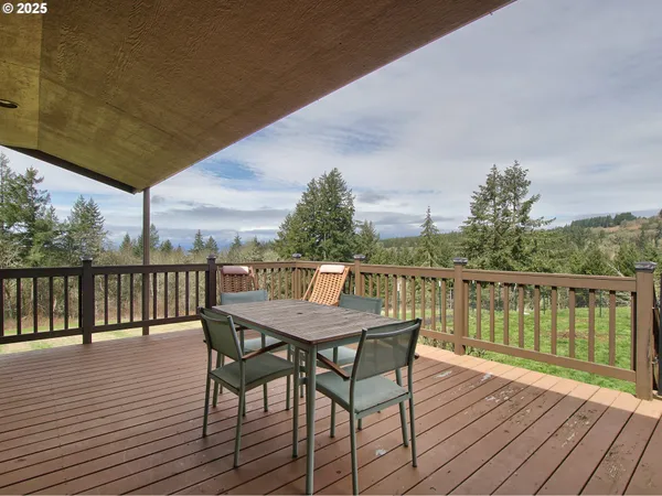 a view of a wooden chairs and table on the deck