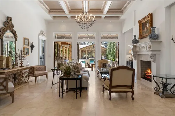 a living room with furniture a fireplace and a chandelier