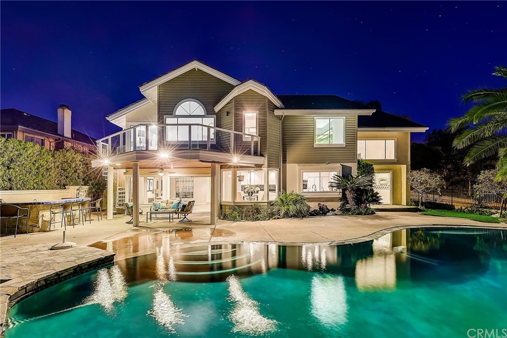 a front view of a house with swimming pool having outdoor seating