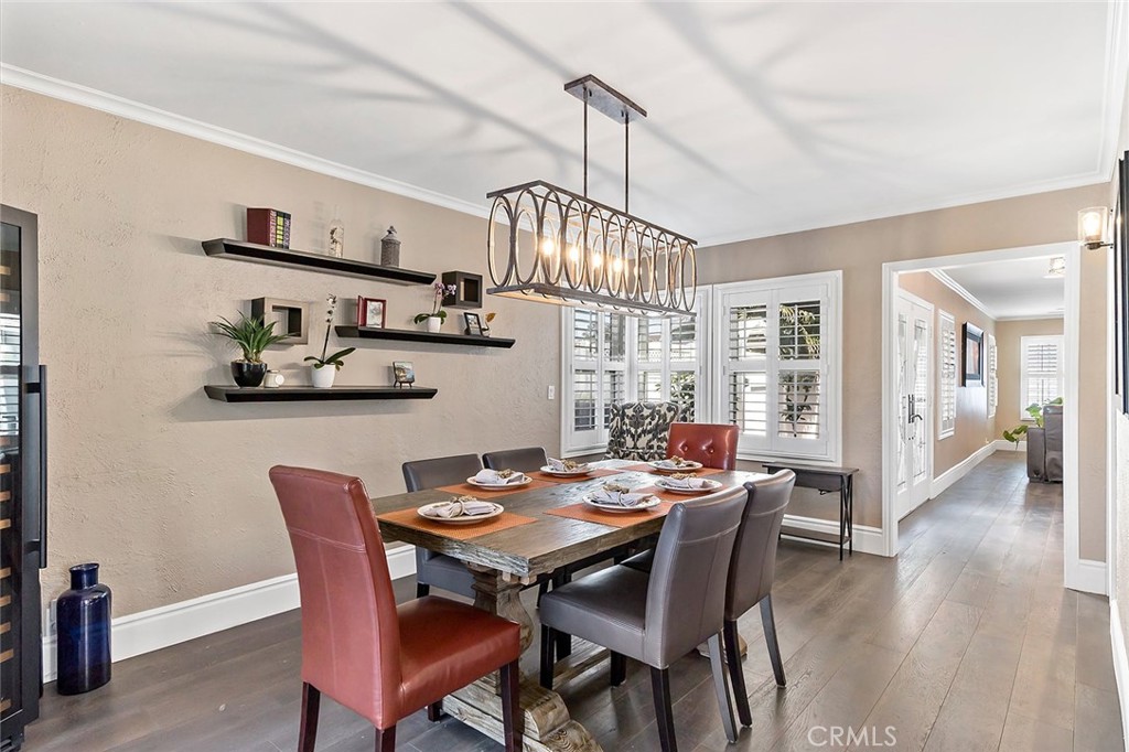 5733 2nd Street Long Beach, CA 90803 - Photo 13 of 32 a dining room with wooden floor a chandelier a wooden table and chairs