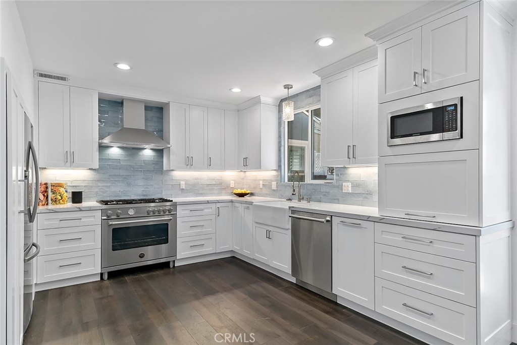 5733 2nd Street Long Beach, CA 90803 - Photo 6 of 32 a kitchen with kitchen island granite countertop white cabinets and white stainless steel appliances