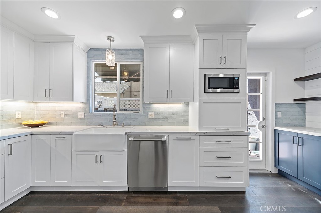 5733 2nd Street Long Beach, CA 90803 - Photo 7 of 32 a kitchen with stainless steel appliances kitchen island granite countertop a sink and dishwasher a stove with wooden floors