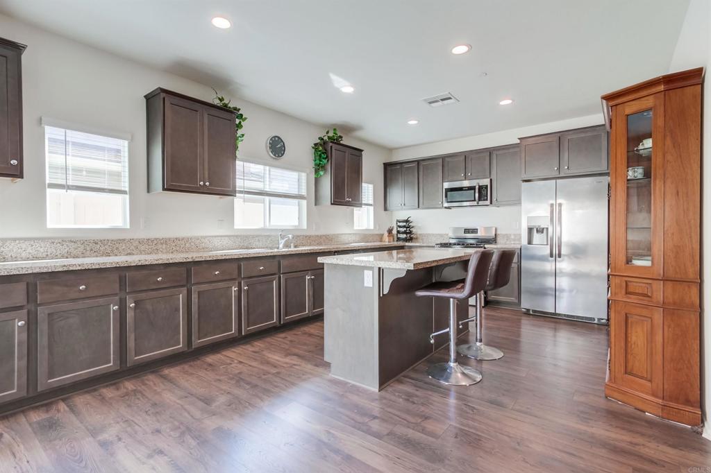 235 Spotted Saddle Way Fallbrook, CA 92028 - Photo 19 of 71 a kitchen with kitchen island granite countertop a sink a counter top space stainless steel appliances and cabinets