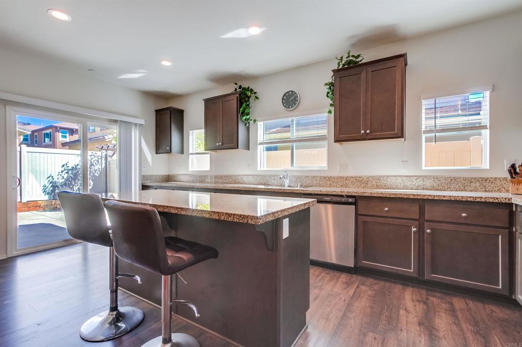 235 Spotted Saddle Way Fallbrook, CA 92028 - Photo 20 of 71 a kitchen with granite countertop a sink cabinets and wooden floor