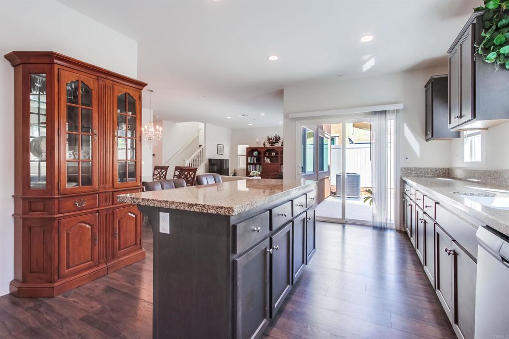235 Spotted Saddle Way Fallbrook, CA 92028 - Photo 24 of 71 a kitchen with stainless steel appliances granite countertop a stove a sink dishwasher and a refrigerator with wooden floor