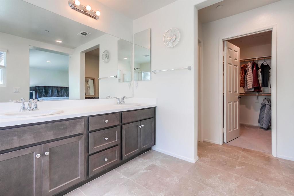 235 Spotted Saddle Way Fallbrook, CA 92028 - Photo 32 of 71 a bathroom with a double vanity sink and a mirror