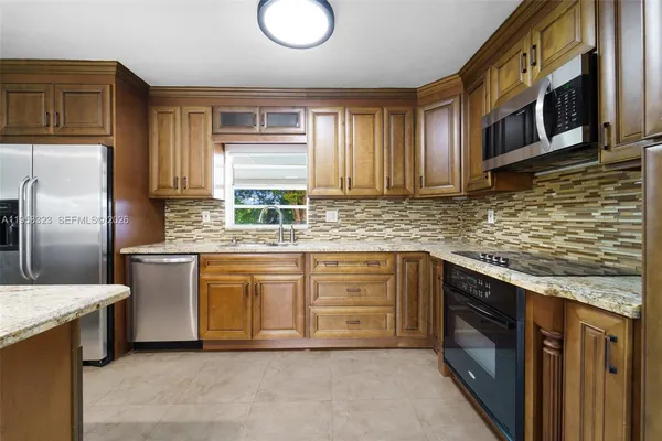 a kitchen with stainless steel appliances granite countertop a sink stove and refrigerator